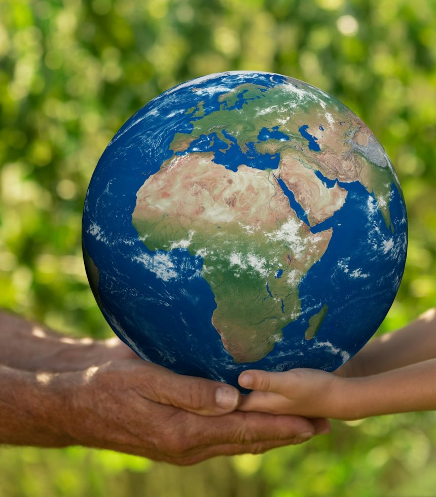 Senior man and child holding Earth planet. Elements of this image furnished by NASA